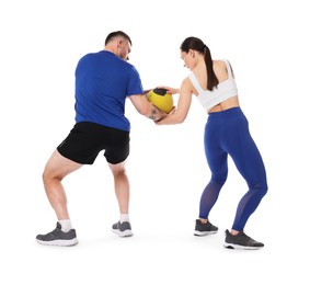 Photo of Woman and man exercising with medicine ball on white background