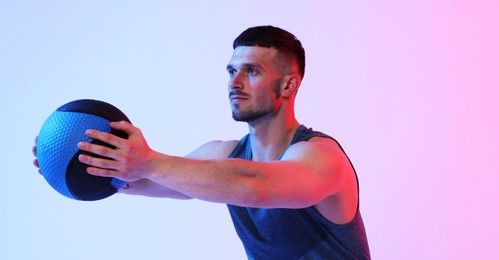 Photo of Man exercising with medicine ball on color background
