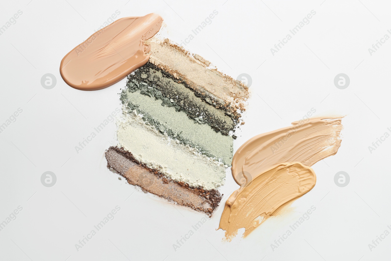 Colorful eyeshadows and foundation on white background, flat lay Photo of Colorful eyeshadows and foundation on white background, flat lay
