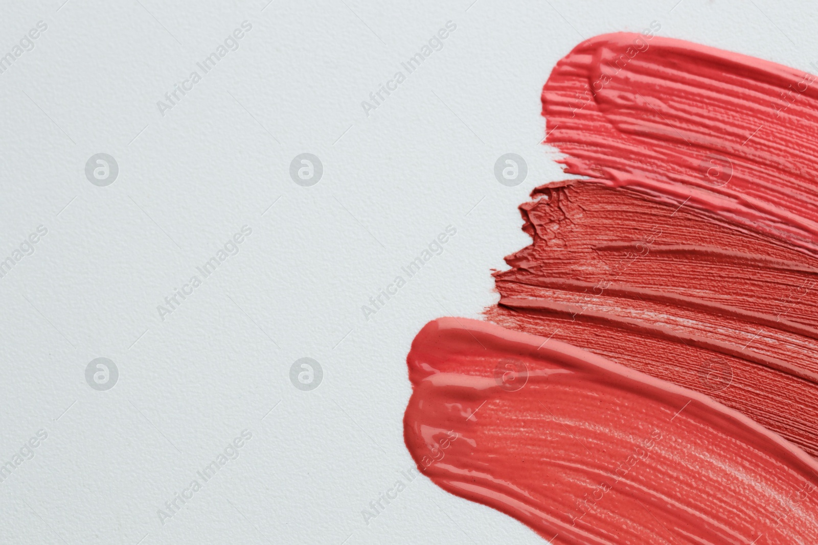 Colorful lip glosses on grey background, flat lay. Space for text Photo of Colorful lip glosses on grey background, flat lay. Space for text