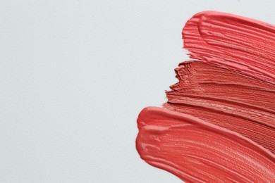 Photo of Colorful lip glosses on grey background, flat lay. Space for text