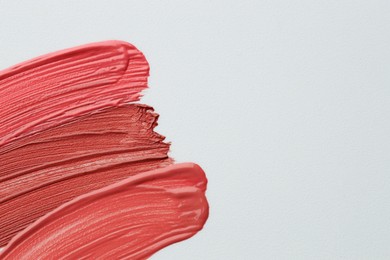 Photo of Colorful lip glosses on grey background, flat lay. Space for text