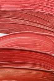 Photo of Colorful lip glosses as background, top view