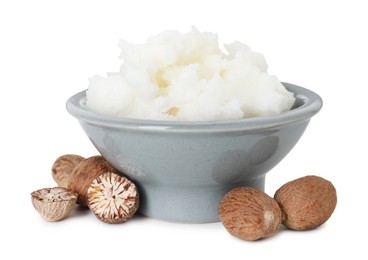 Photo of Shea butter in bowl and nuts isolated on white