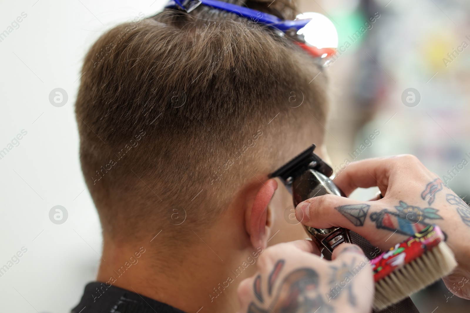 Professional barber making stylish haircut in barbershop, closeup Photo of Professional barber making stylish haircut in barbershop, closeup