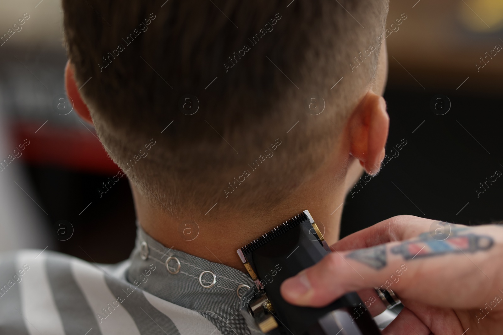 Professional barber working with client in barbershop, closeup Photo of Professional barber working with client in barbershop, closeup