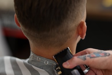 Photo of Professional barber working with client in barbershop, closeup
