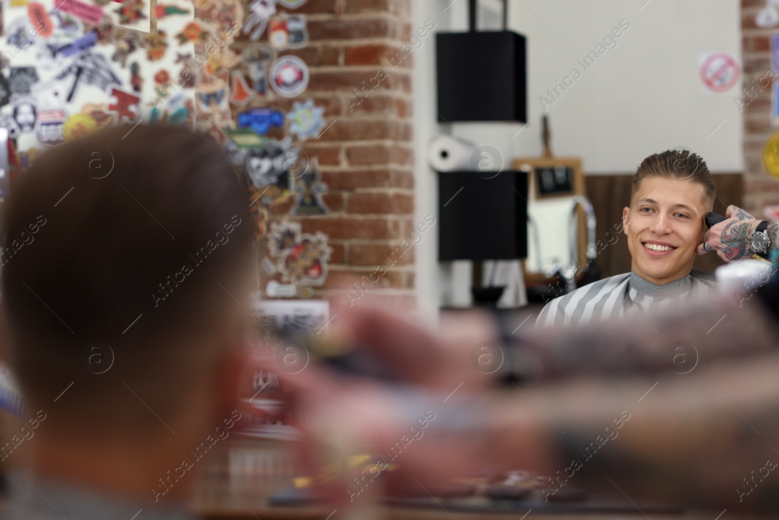 Professional barber working with client in barbershop, closeup Photo of Professional barber working with client in barbershop, closeup