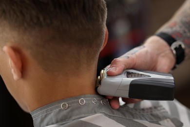Photo of Professional barber working with client in barbershop, closeup