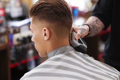Photo of Professional barber working with client in barbershop, closeup