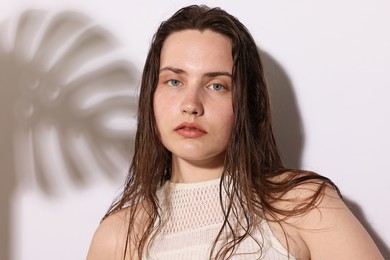 Photo of Portrait of beautiful woman with natural skin complexion on light background with shadows, closeup