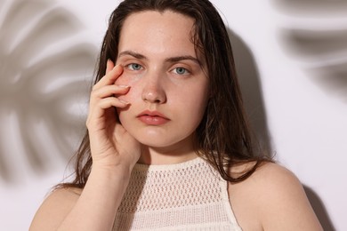 Photo of Portrait of beautiful woman with natural skin complexion on light background with shadows, closeup