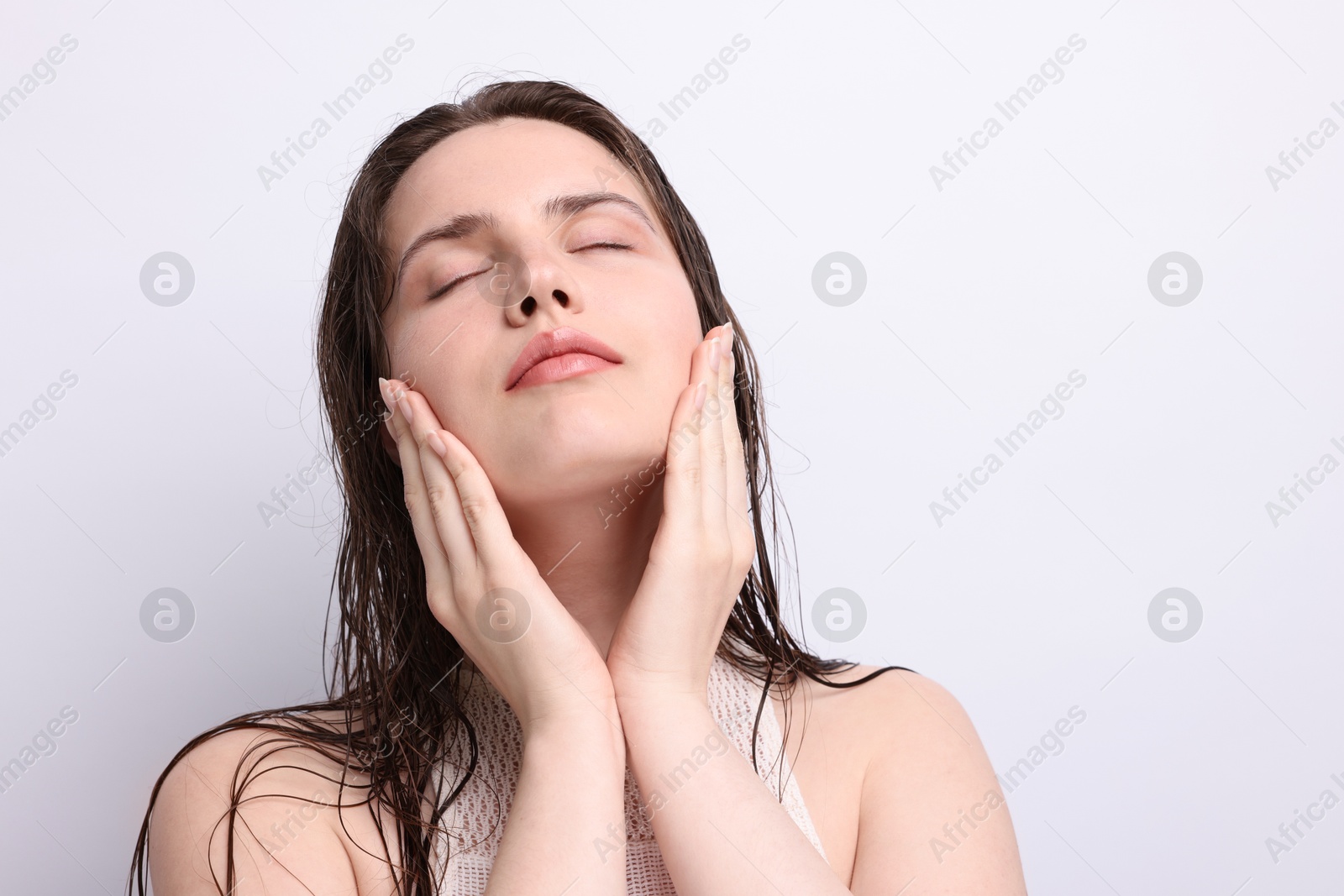 Beautiful woman with natural skin complexion on light grey background, closeup Photo of Beautiful woman with natural skin complexion on light grey background, closeup