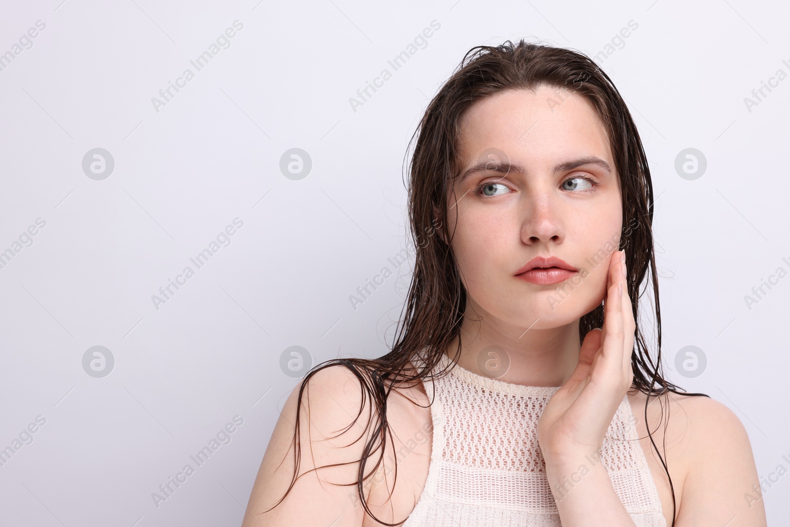 Beautiful woman with natural skin complexion on light grey background, closeup. Space for text Photo of Beautiful woman with natural skin complexion on light grey background, closeup. Space for text