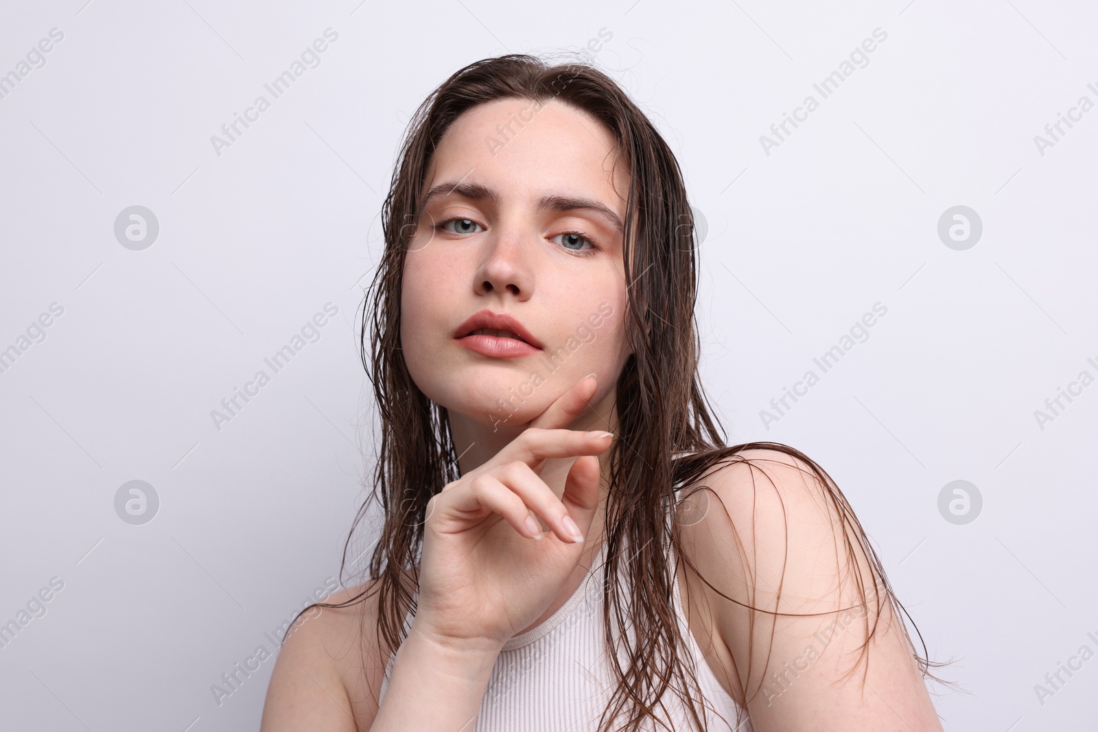 Portrait of beautiful woman with natural skin complexion on light grey background, closeup Photo of Portrait of beautiful woman with natural skin complexion on light grey background, closeup