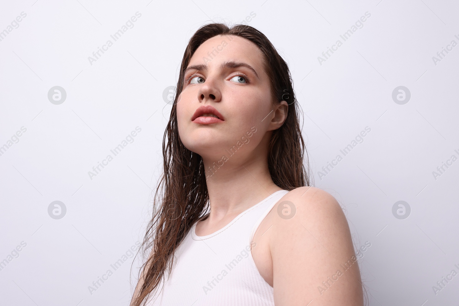 Beautiful woman with natural skin complexion on light grey background, low angle view Photo of Beautiful woman with natural skin complexion on light grey background, low angle view