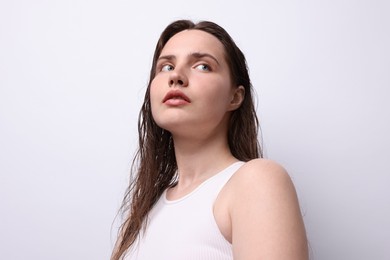 Photo of Beautiful woman with natural skin complexion on light grey background, low angle view