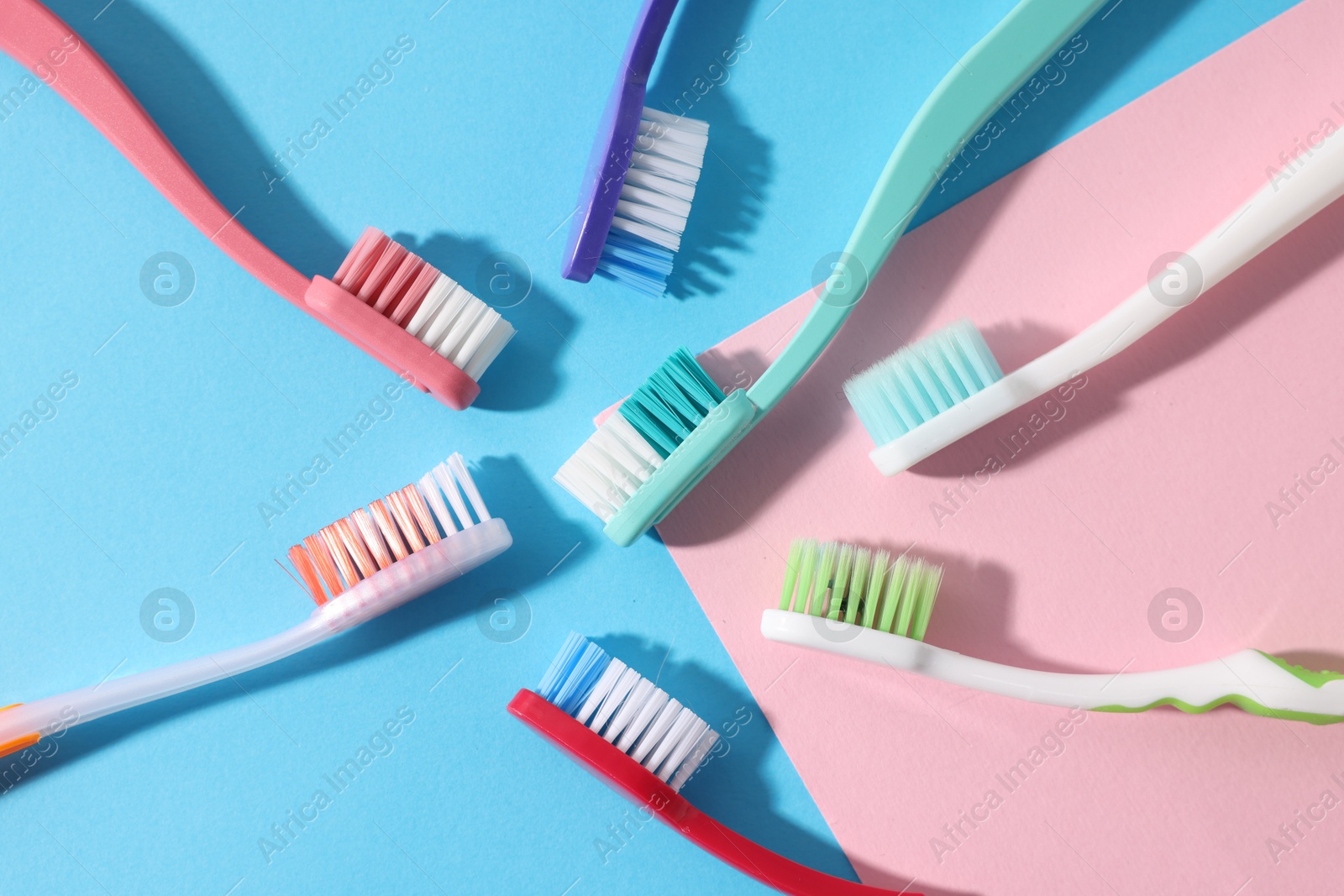 Different toothbrushes on color background, flat lay Photo of Different toothbrushes on color background, flat lay