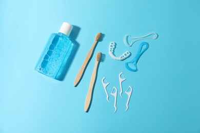 Photo of Different oral care products on light blue background, flat lay