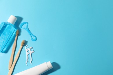Photo of Different oral care products on light blue background, flat lay. Space for text