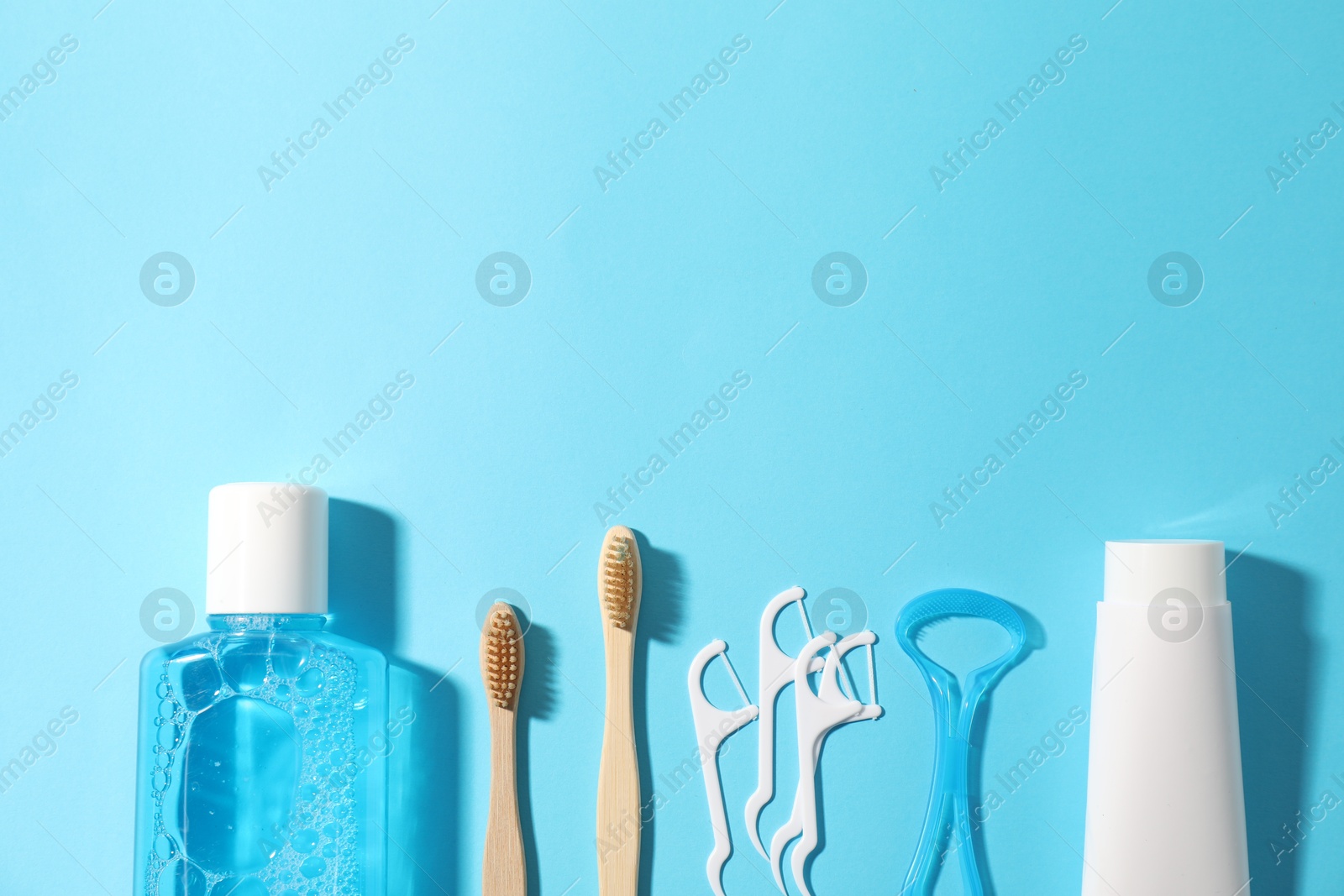Different oral care products on light blue background, flat lay. Space for text Photo of Different oral care products on light blue background, flat lay. Space for text