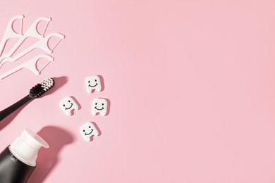 Photo of Different oral care products and teeth figures on pink background, flat lay. Space for text