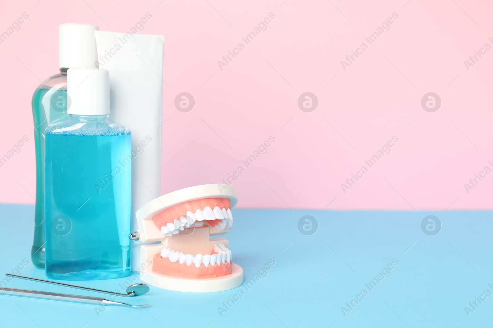 Different oral care products and dental model on color background. Space for text Photo of Different oral care products and dental model on color background. Space for text