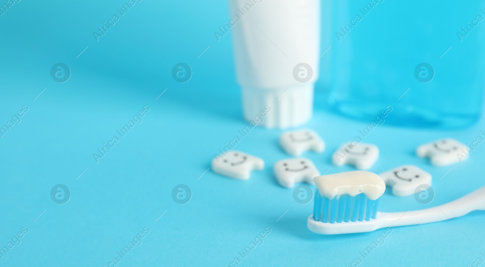Different oral care products and teeth figures on light blue background, closeup. Space for text Photo of Different oral care products and teeth figures on light blue background, closeup. Space for text
