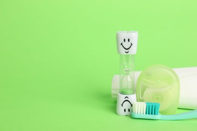 Photo of Different oral care products on green background. Space for text