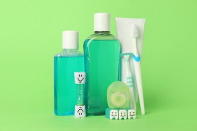 Photo of Different oral care products and teeth figures on green background