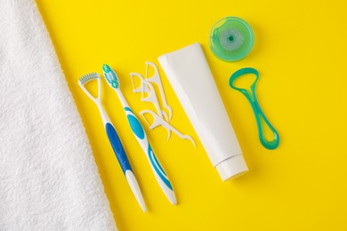Photo of Different oral care products on yellow background, flat lay
