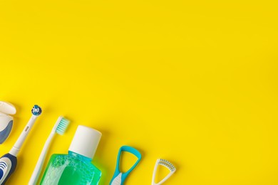 Photo of Different oral care products on yellow background, flat lay. Space for text