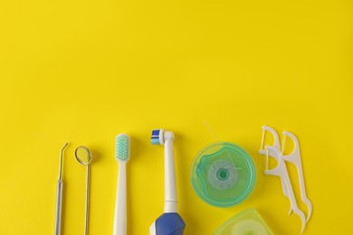 Photo of Different oral care products on yellow background, flat lay. Space for text
