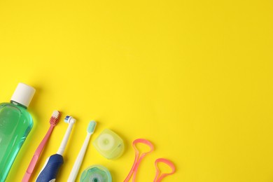 Photo of Different oral care products on yellow background, flat lay. Space for text