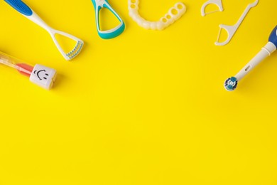 Photo of Different oral care products on yellow background, flat lay. Space for text