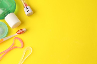 Photo of Different oral care products on yellow background, flat lay. Space for text