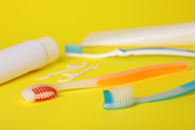 Photo of Different oral care products on yellow background, closeup