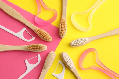 Photo of Toothbrushes, tongue cleaners and floss picks on color background, flat lay