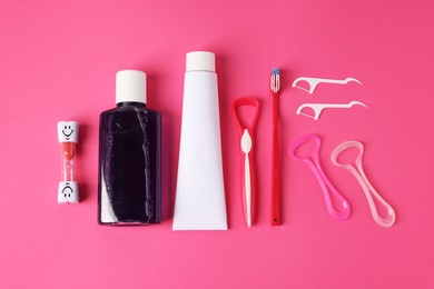 Photo of Different oral care products on pink background, flat lay