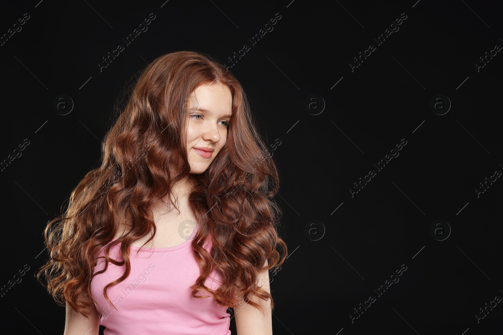 Beautiful teenage girl with healthy wavy hair on black background. Space for text Photo of Beautiful teenage girl with healthy wavy hair on black background. Space for text
