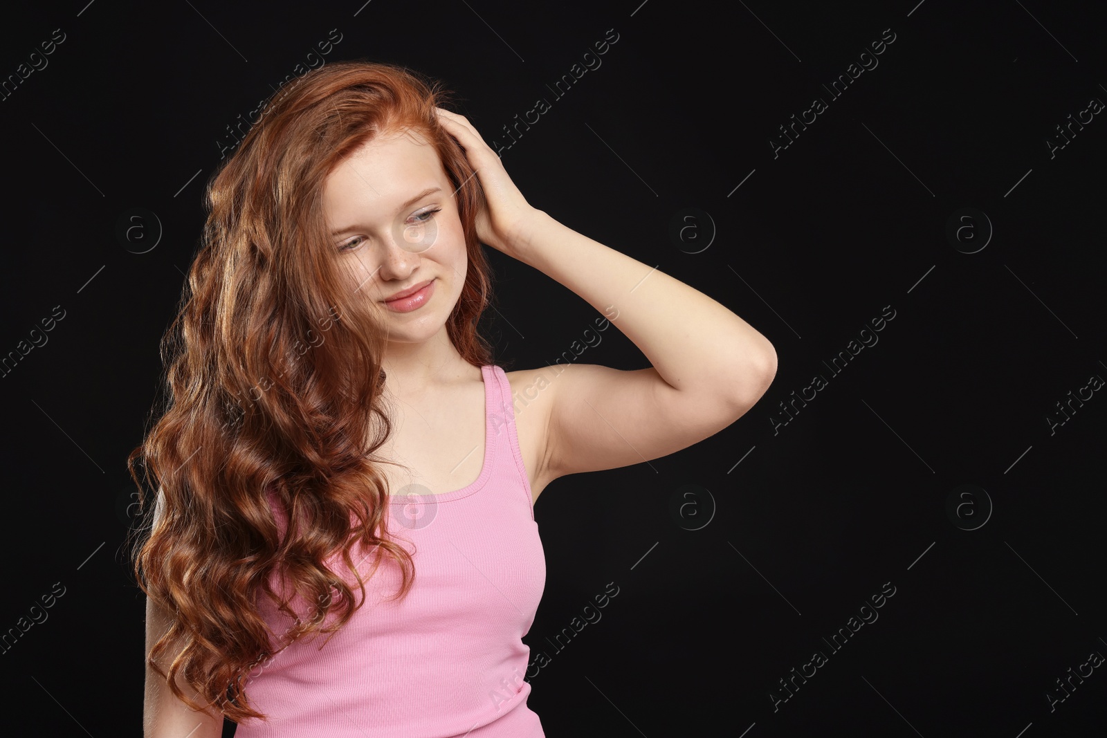Beautiful teenage girl with healthy wavy hair on black background. Space for text Photo of Beautiful teenage girl with healthy wavy hair on black background. Space for text