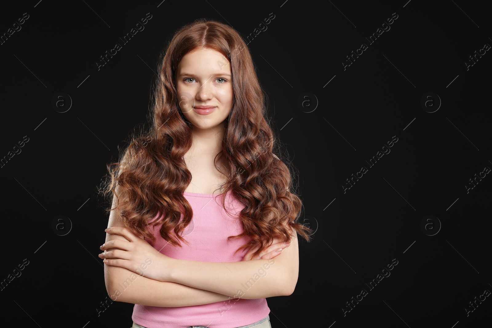Portrait of beautiful teenage girl with healthy wavy hair on black background Photo of Portrait of beautiful teenage girl with healthy wavy hair on black background
