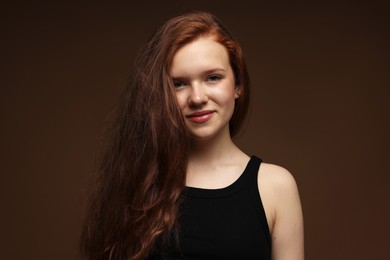 Photo of Portrait of beautiful teenage girl with healthy wavy hair on brown background