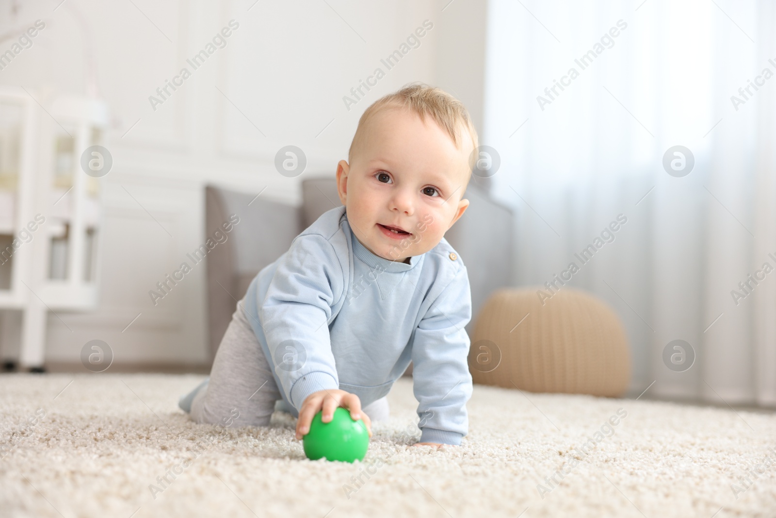 Cute little baby crawling on floor at home Photo of Cute little baby crawling on floor at home