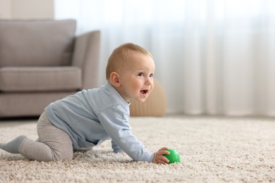 Photo of Cute little baby crawling on floor at home, space for text