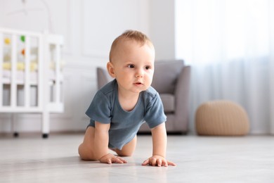 Photo of Cute little baby crawling on floor at home