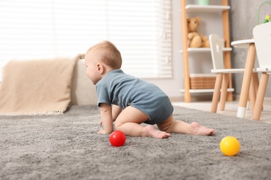Photo of Cute little baby crawling on floor at home