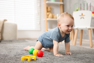 Photo of Cute little baby crawling on floor at home, space for text