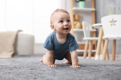 Photo of Cute little baby crawling on floor at home