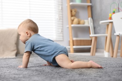 Photo of Cute little baby crawling on floor at home
